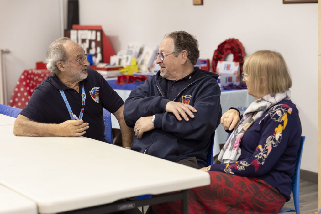 Staff members sat at a table speaking to each other.