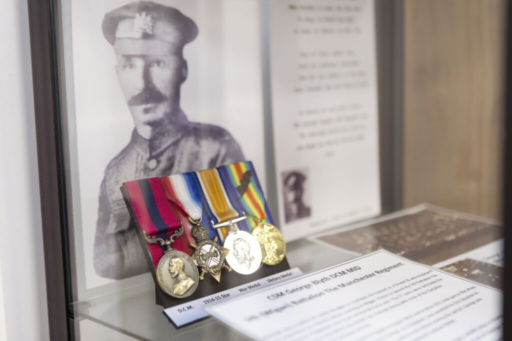 An image of solider's medals in a glass case.