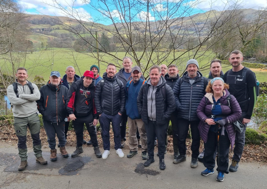 A group of professionals and veterans on a hike, relating to Tom Harrison House.